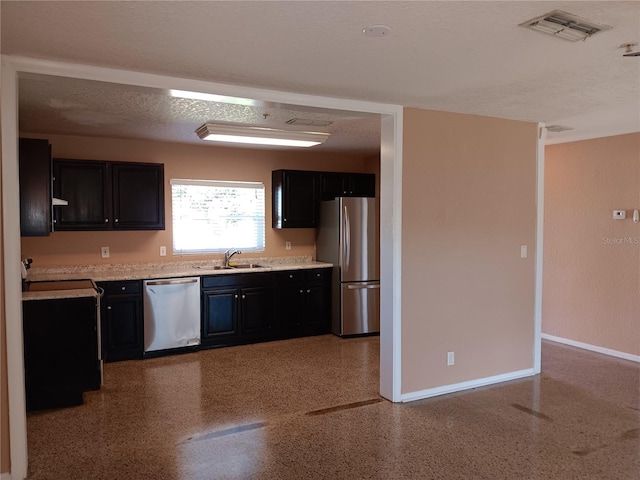 kitchen featuring sink, stainless steel appliances, and a textured ceiling