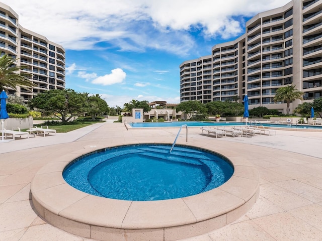 view of swimming pool with a patio area and a community hot tub