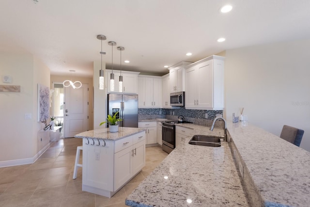 kitchen with a kitchen bar, stainless steel appliances, white cabinetry, and sink