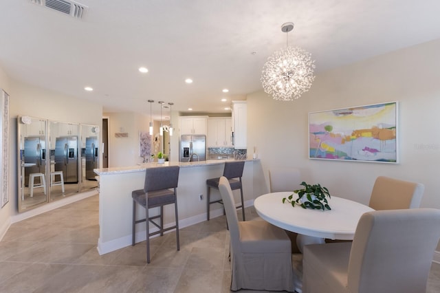 dining room with a notable chandelier and light tile patterned flooring