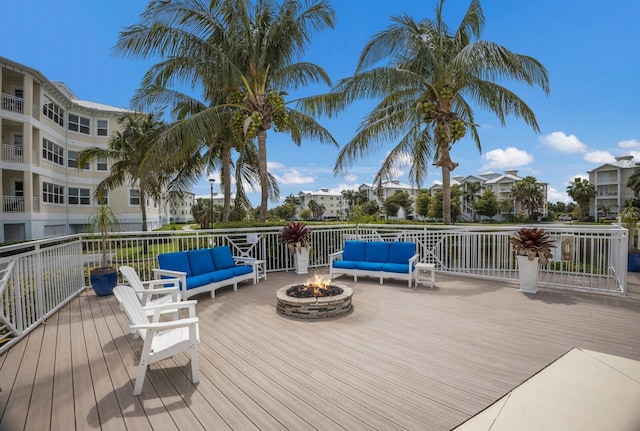 wooden terrace featuring an outdoor living space with a fire pit