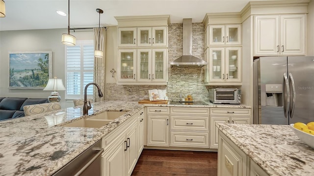 kitchen featuring stainless steel appliances, dark hardwood / wood-style floors, tasteful backsplash, wall chimney range hood, and sink