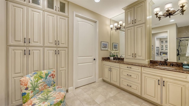 bathroom with a chandelier, tile patterned floors, a shower, and vanity