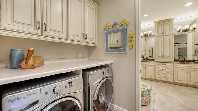 laundry room featuring washer and clothes dryer, cabinets, sink, a chandelier, and light tile patterned floors