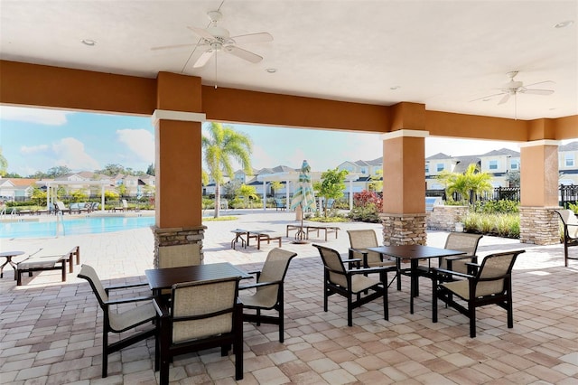 view of patio with ceiling fan and a community pool