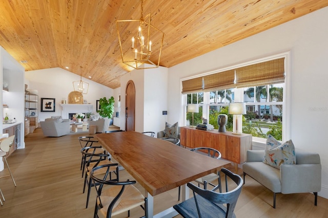 dining area with light wood-type flooring, vaulted ceiling, an inviting chandelier, and wooden ceiling