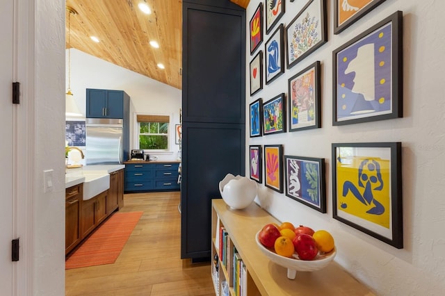 hall featuring lofted ceiling, wood ceiling, sink, and light hardwood / wood-style floors