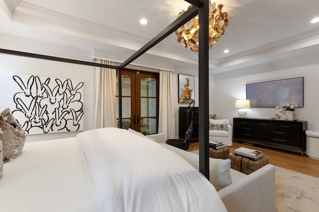 bedroom with hardwood / wood-style floors, ornamental molding, and french doors