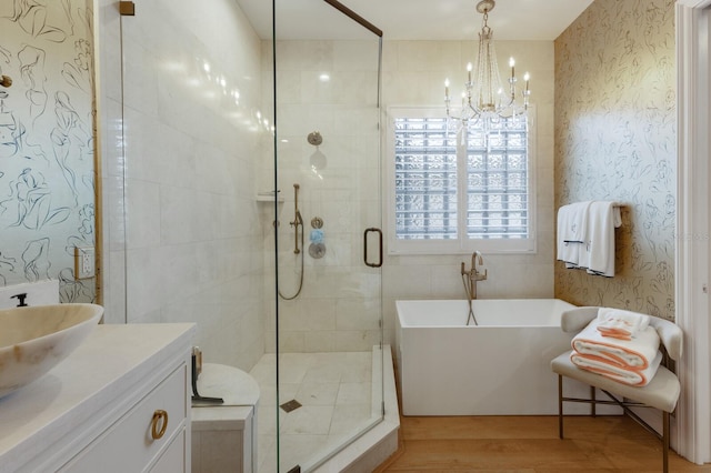 bathroom with vanity, a notable chandelier, plus walk in shower, and hardwood / wood-style flooring