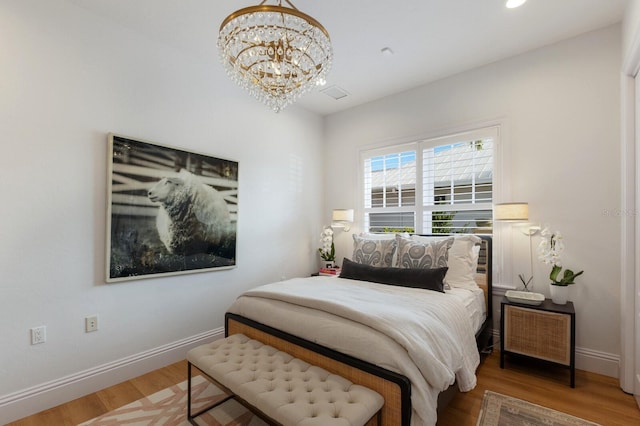 bedroom featuring a chandelier and hardwood / wood-style floors