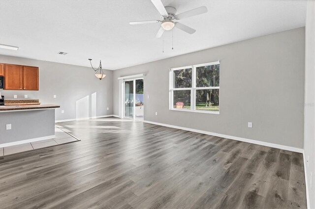 unfurnished living room with ceiling fan and wood-type flooring