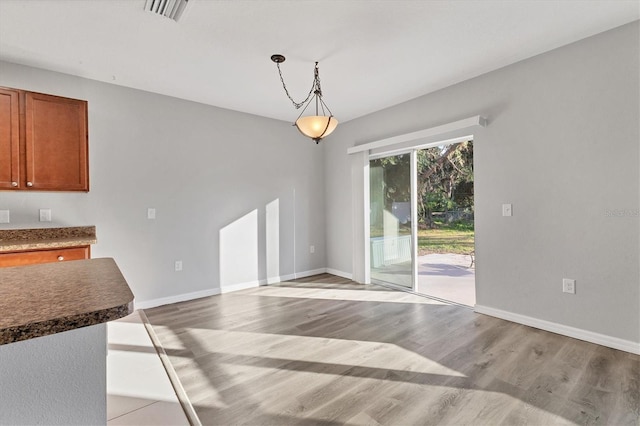 unfurnished dining area with light wood-type flooring