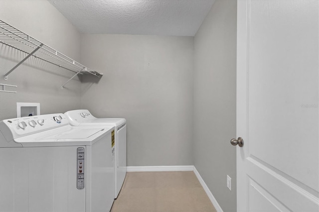 laundry room with a textured ceiling and independent washer and dryer