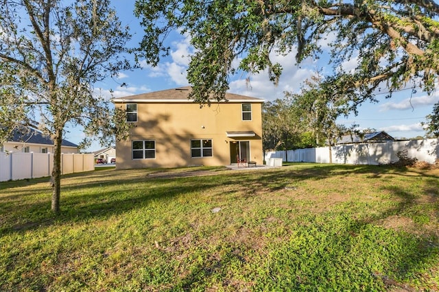 back of house featuring a patio area and a yard