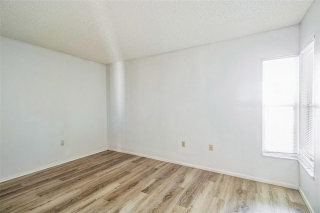 empty room featuring light hardwood / wood-style floors and a textured ceiling