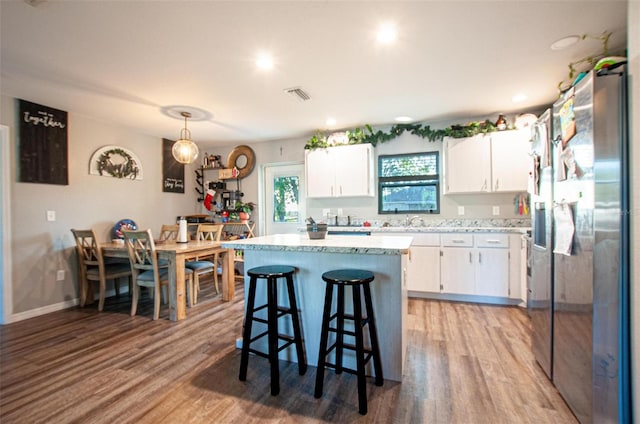 kitchen featuring a center island, light hardwood / wood-style flooring, white cabinets, and pendant lighting