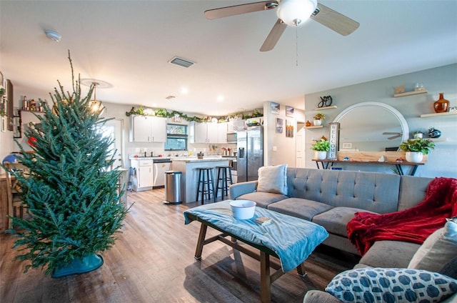 living room with ceiling fan and light hardwood / wood-style floors