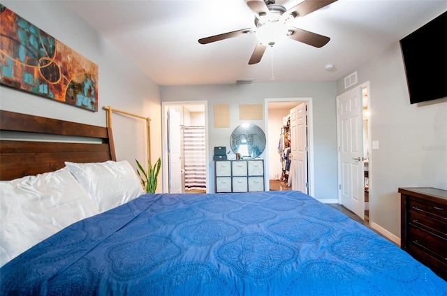 bedroom featuring ensuite bath, ceiling fan, and a walk in closet