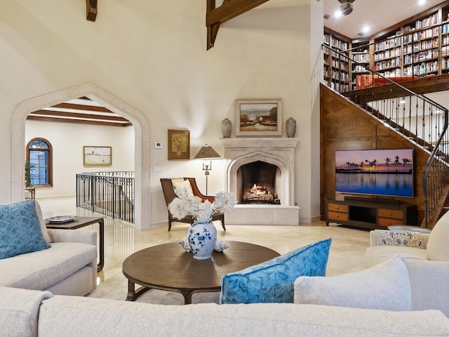 living room with beamed ceiling and a high ceiling