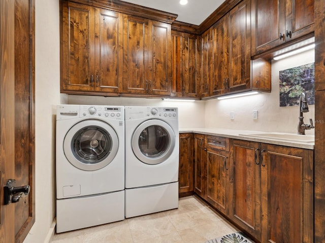 laundry area with washer and clothes dryer, light tile patterned flooring, cabinets, and sink