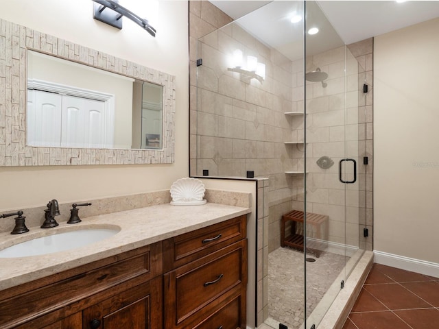 bathroom with tile patterned flooring, vanity, and a shower with door