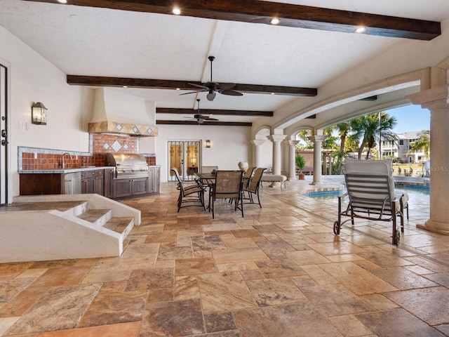 view of patio / terrace with area for grilling, ceiling fan, and exterior kitchen