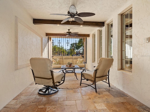 sunroom / solarium with beamed ceiling and ceiling fan