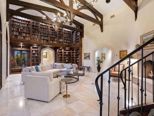 living room with beam ceiling, a towering ceiling, and an inviting chandelier