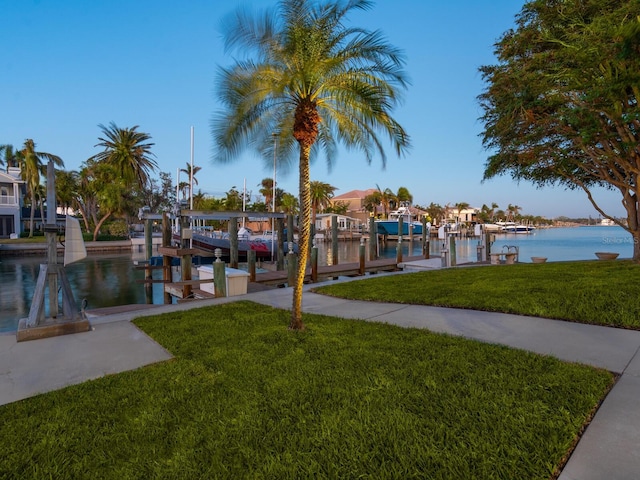 view of dock featuring a water view and a lawn