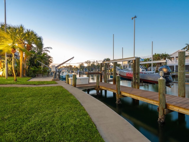 dock area with a water view and a yard