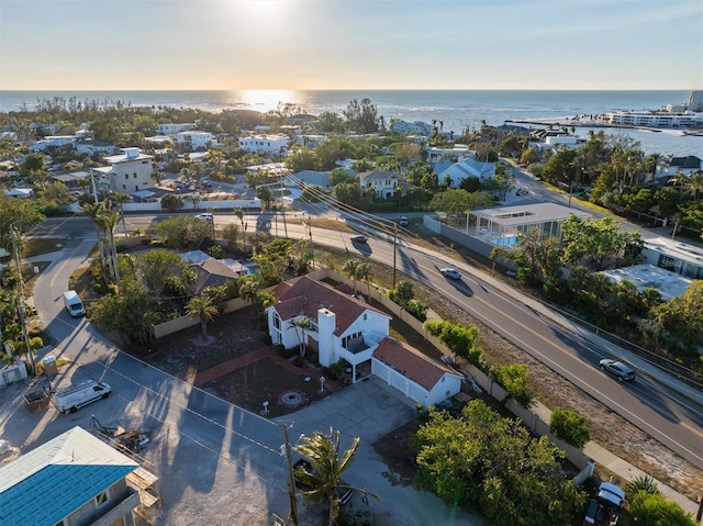 aerial view at dusk featuring a water view