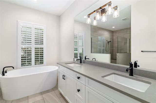 bathroom featuring tile patterned flooring, shower with separate bathtub, vanity, and a wealth of natural light