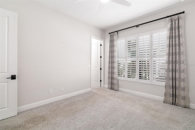 empty room featuring ceiling fan and light carpet