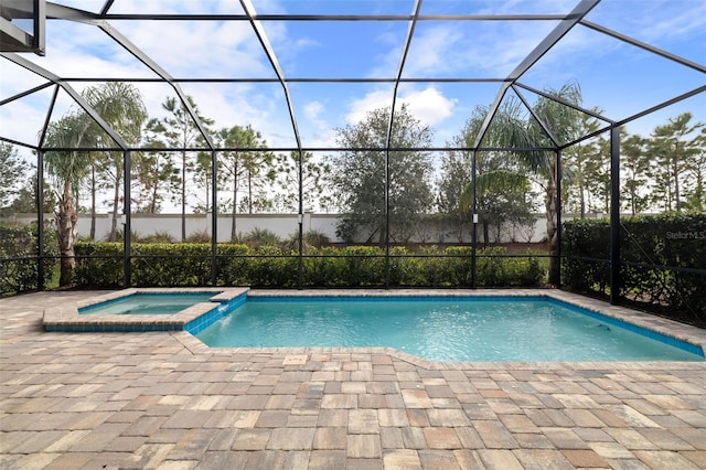 view of swimming pool featuring an in ground hot tub, a patio, and glass enclosure