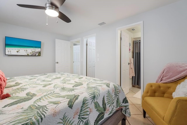 bedroom with ceiling fan, light tile patterned floors, and ensuite bath