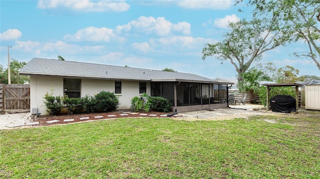 back of house featuring a patio area, a sunroom, and a yard