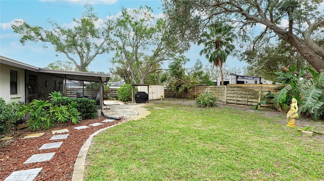 view of yard with a sunroom and a storage unit