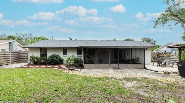 back of house with a patio area, a sunroom, and a lawn