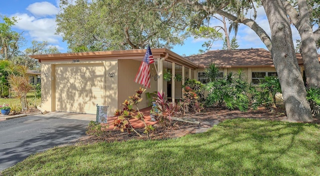 view of front of property with a front yard and a garage