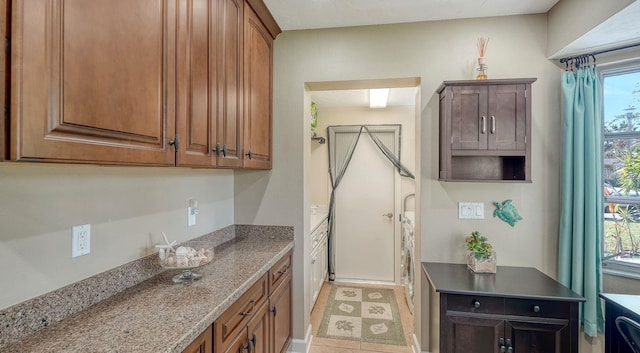 kitchen with light stone countertops, light tile patterned floors, and a wealth of natural light