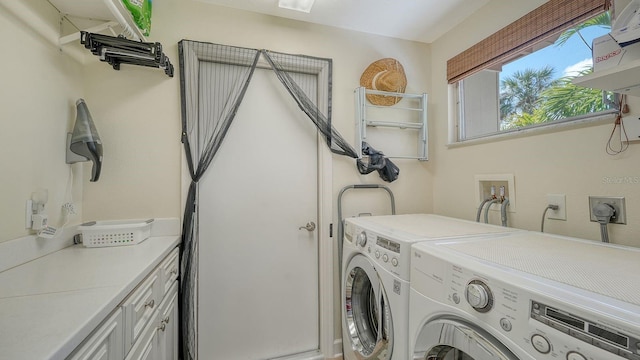 laundry area featuring washing machine and dryer and cabinets