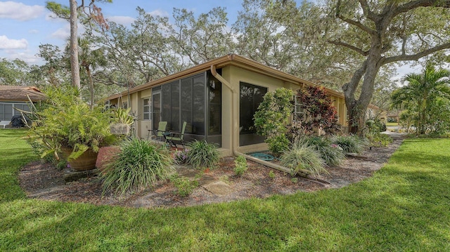 exterior space with a lawn and a sunroom