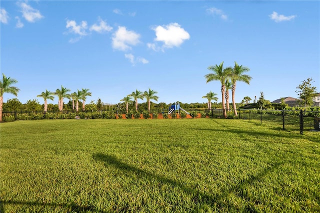 view of yard featuring playground community and fence