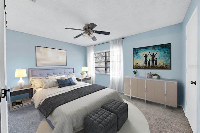 carpeted bedroom featuring ceiling fan and a textured ceiling