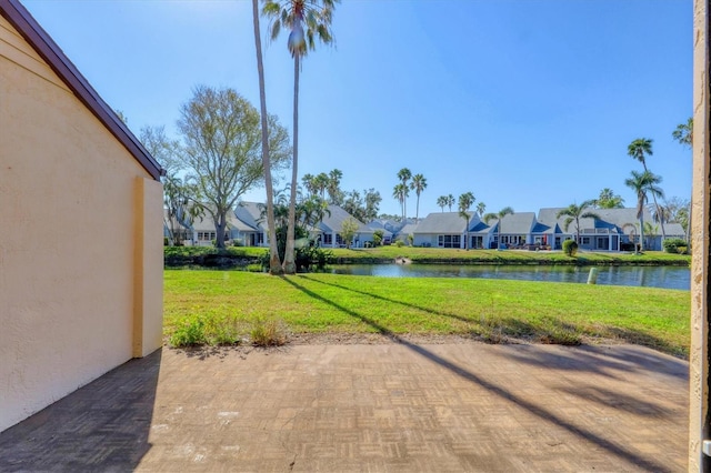 surrounding community with a yard, a water view, and a patio