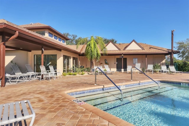 rear view of property featuring a patio area and a community pool