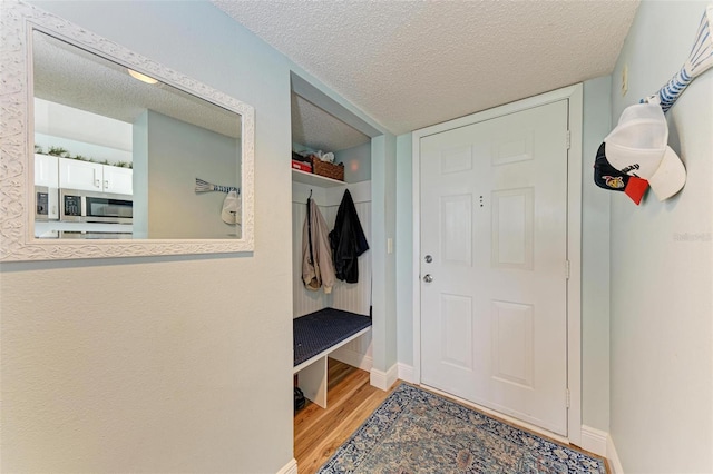 mudroom with a textured ceiling and hardwood / wood-style flooring