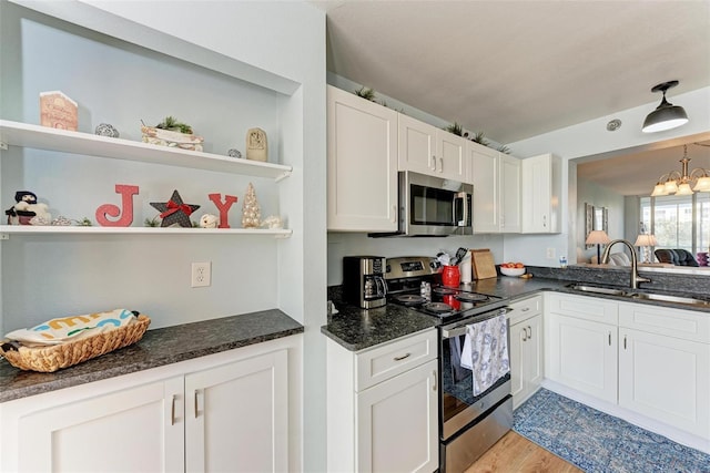 kitchen with white cabinets, light wood-type flooring, sink, and appliances with stainless steel finishes