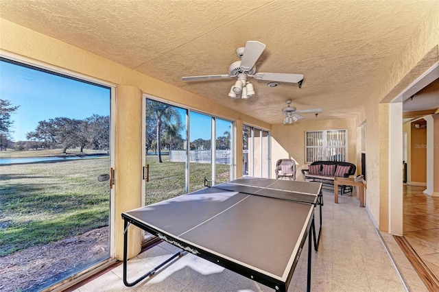 recreation room featuring a water view and ceiling fan