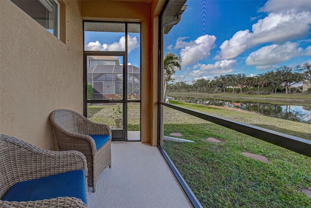 sunroom featuring a water view